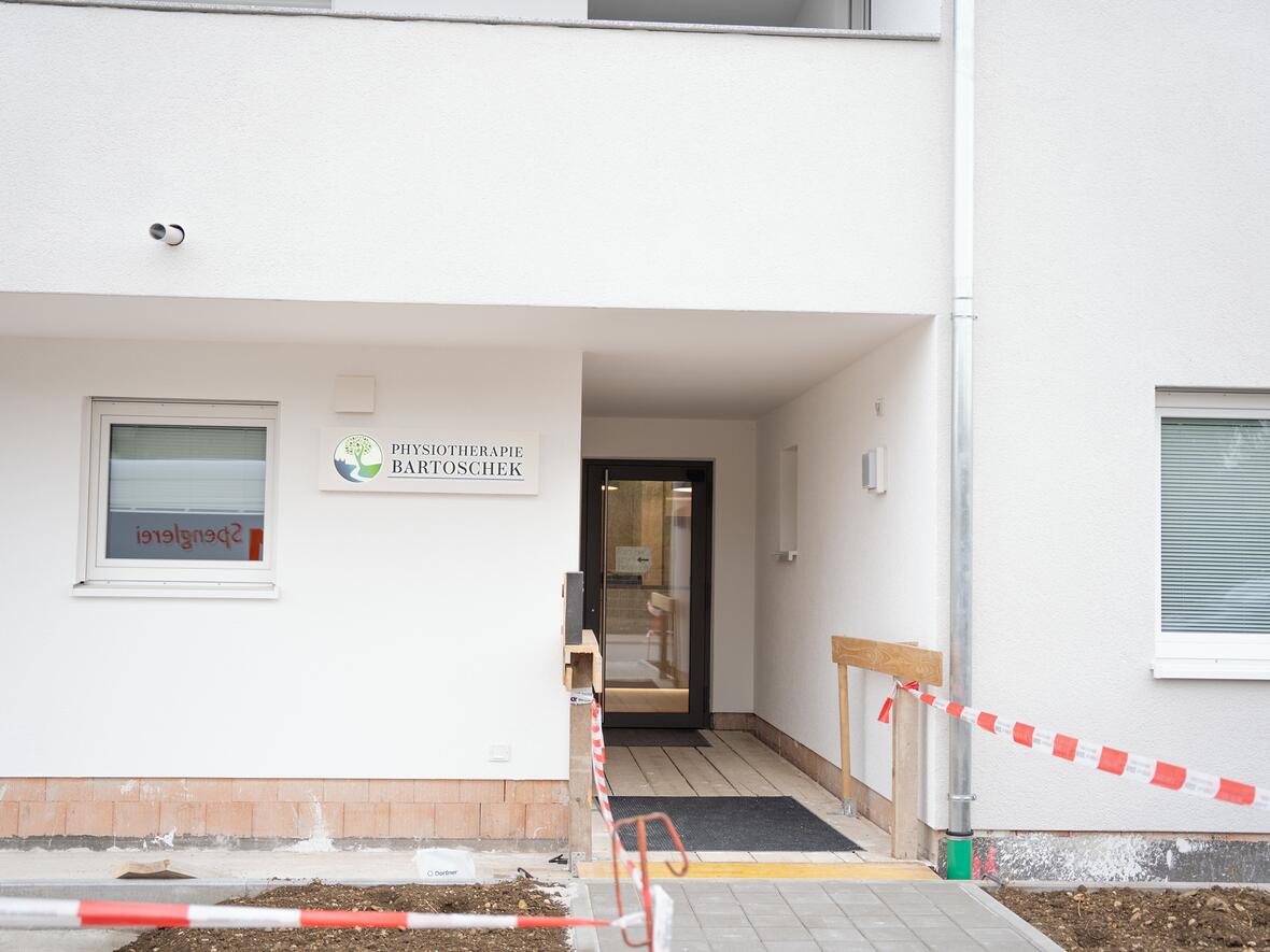 Eingang zur Physiotherapie Bartoschek mit Rampe und Bauabsperrung.
